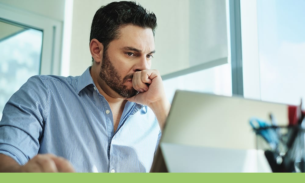 Employee sitting at computer thinking Employee sitting at computer thinking
